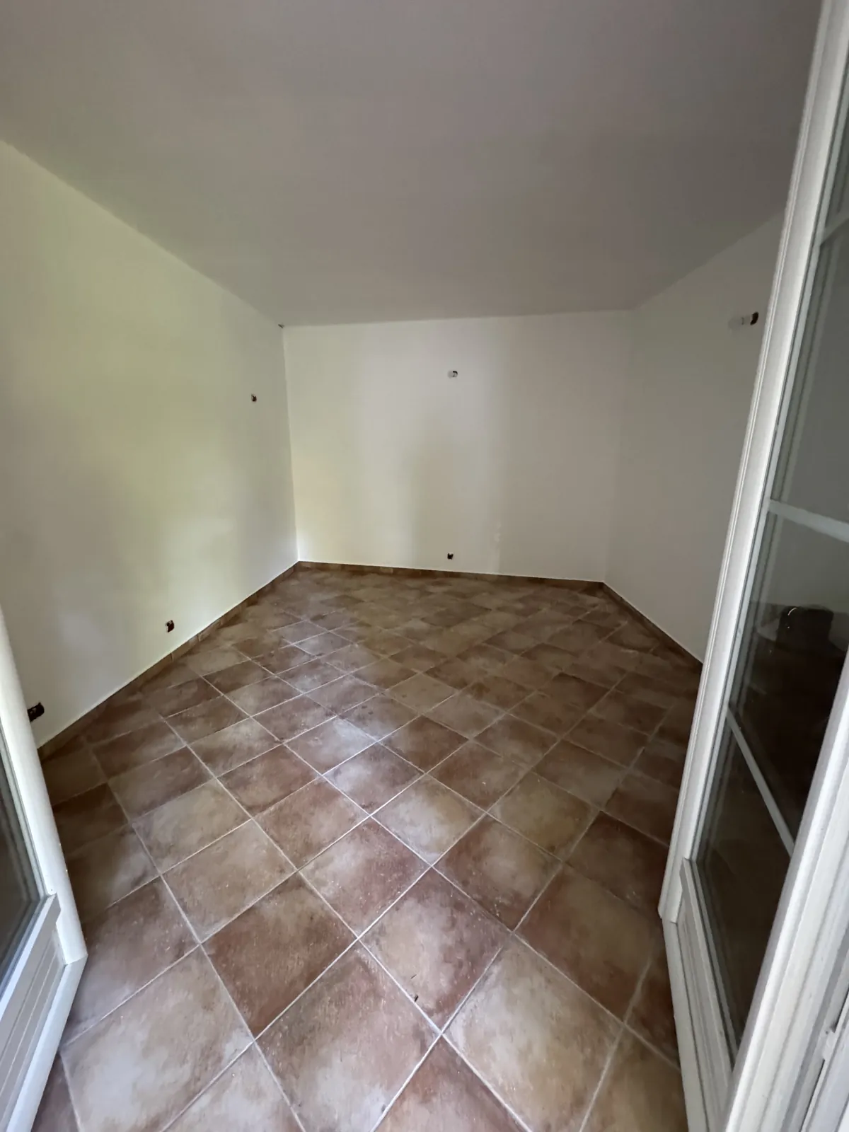 Chambre au sol carrelé, tons terre cuite